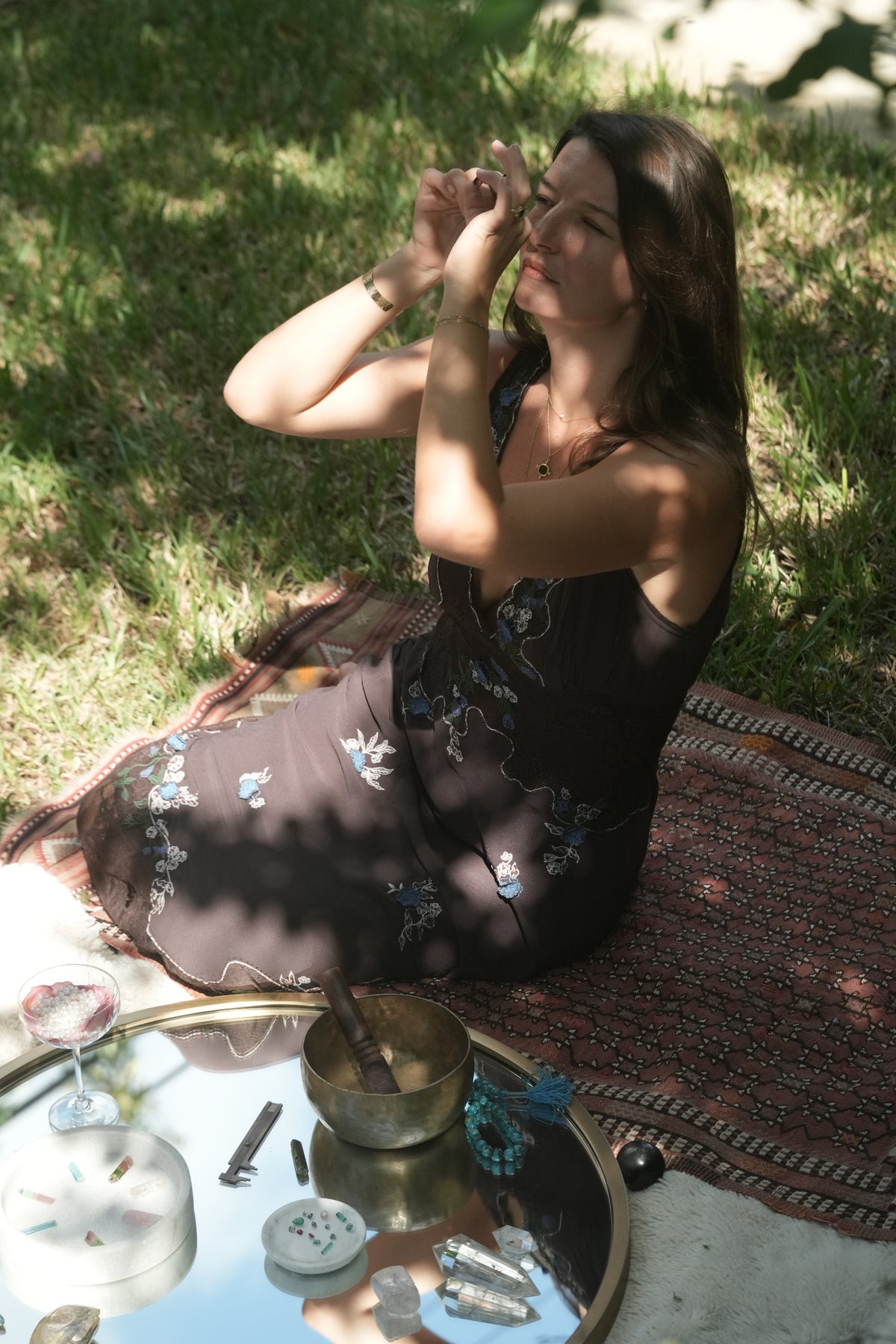 Albisia holding a gemstone up to the daylight to read its color and clarity